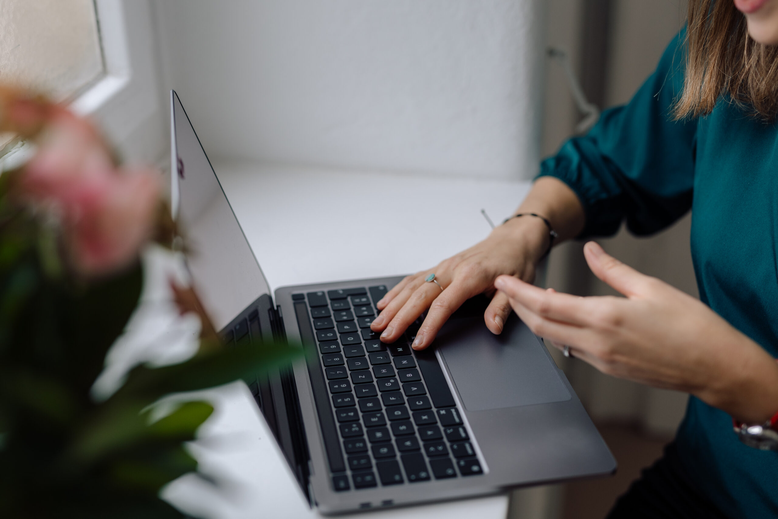 A close-up photograph of a professional typing on a laptop keyboard, representing a life sciences consultant refining a biotech messaging conviction framework and shaping an authoritative communication strategy.